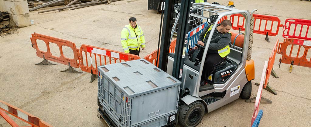 Equipment operator learning to drive a forklift through tight spaces using a guide
