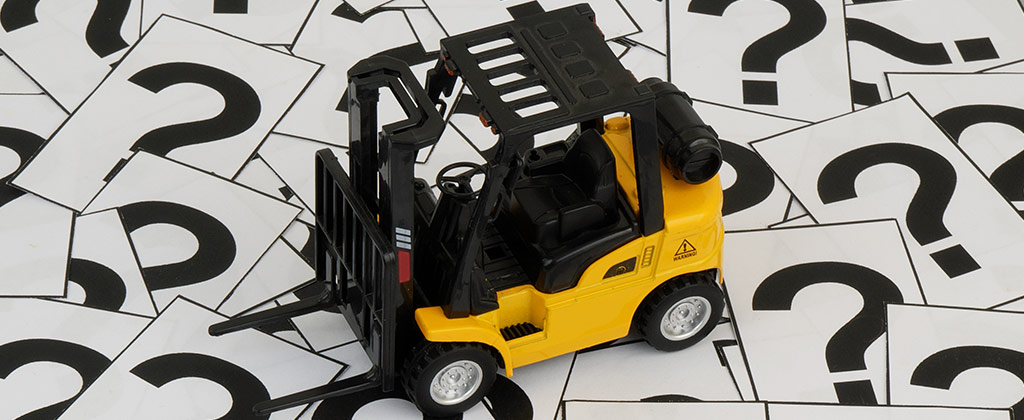 Forklift toy on top of a bunch of question marks for indicating miscellaneous content