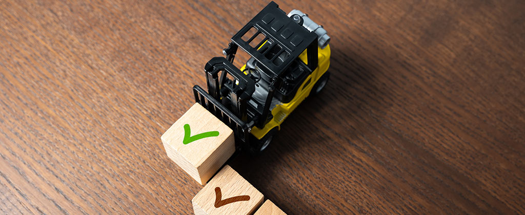Forklift carrying a green checkmark box indicating the customer made the right purchasing decision