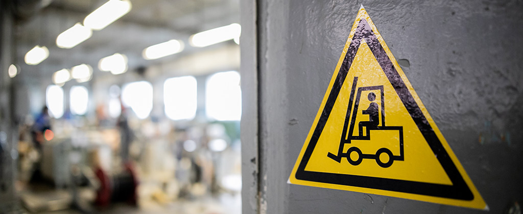 Yellow forklift safety support sticker on a wall to alert caution of equipment traffic in the area